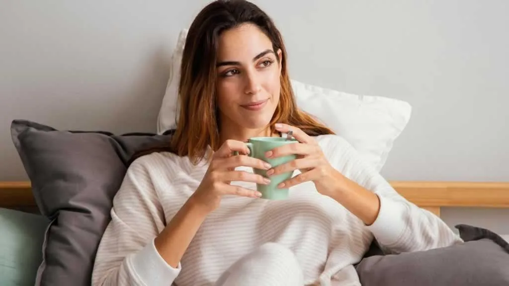women drinking warm tea in bed before sleep